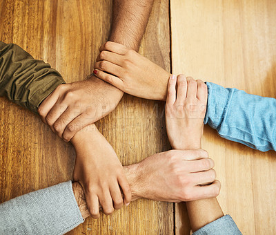 Buy stock photo High angle shot of a group of unrecognizable university students holding one another's wrists as a show of solidarity