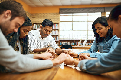 Buy stock photo Students, people and praying together for study, faith and university exam with community in library. Friends, diversity and holding hands on campus for college test, education and Christian society