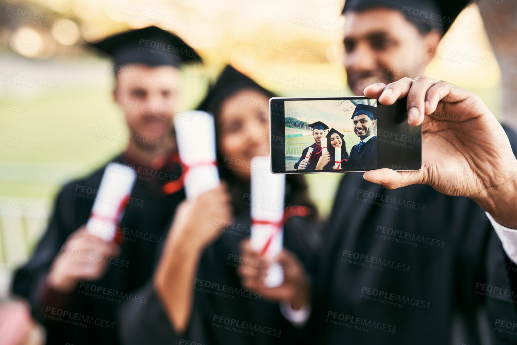 Buy stock photo Shot of a group of students taking a selfie together on graduation day