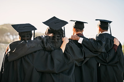 Buy stock photo Rearview shot of a group of students standing together on graduation day