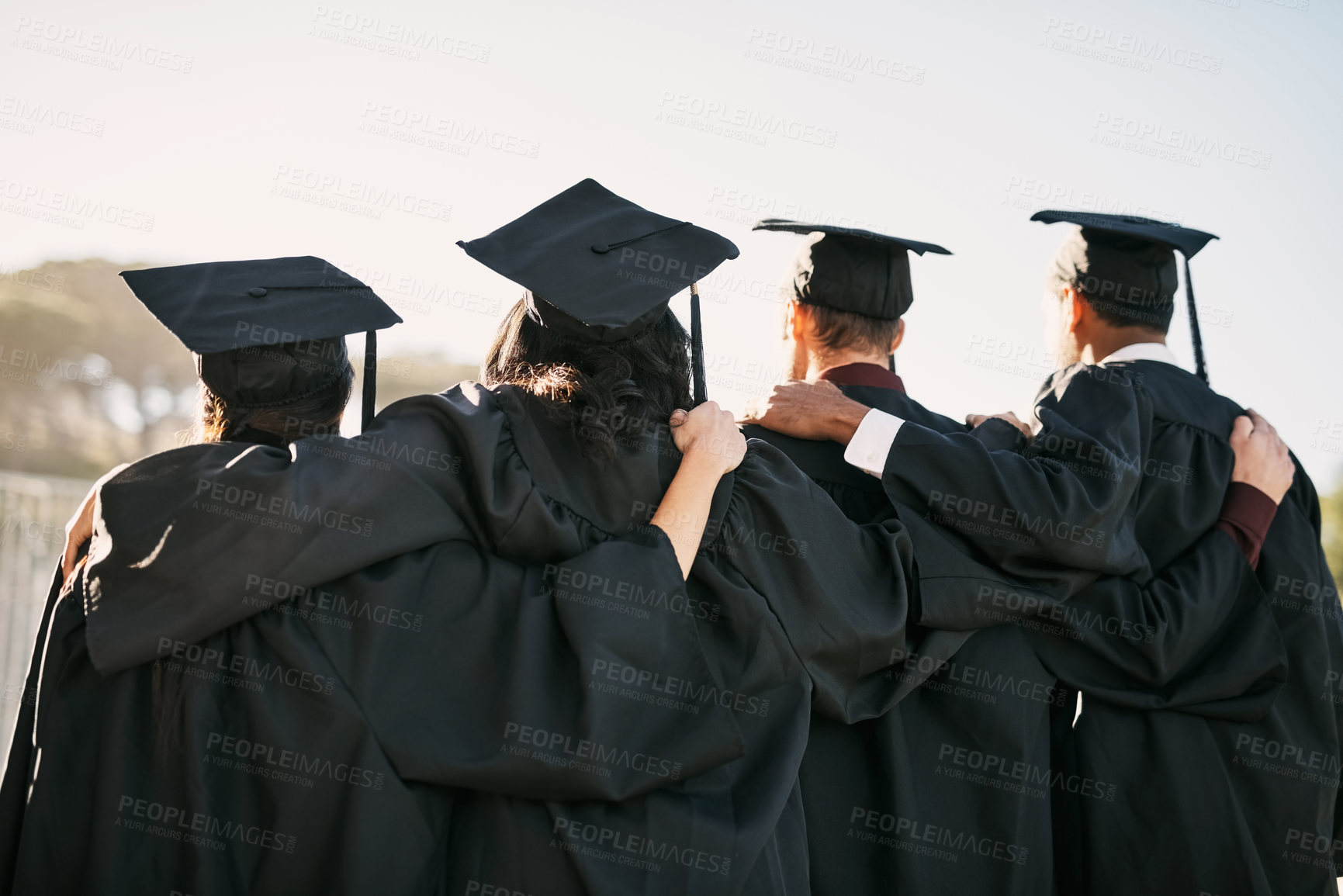 Buy stock photo Rearview shot of a group of students standing together on graduation day