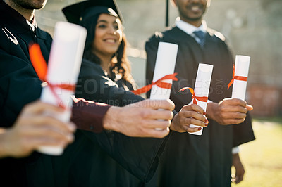 Buy stock photo Closeup shot of a group of unrecognizable students holding their diplomas on graduation day