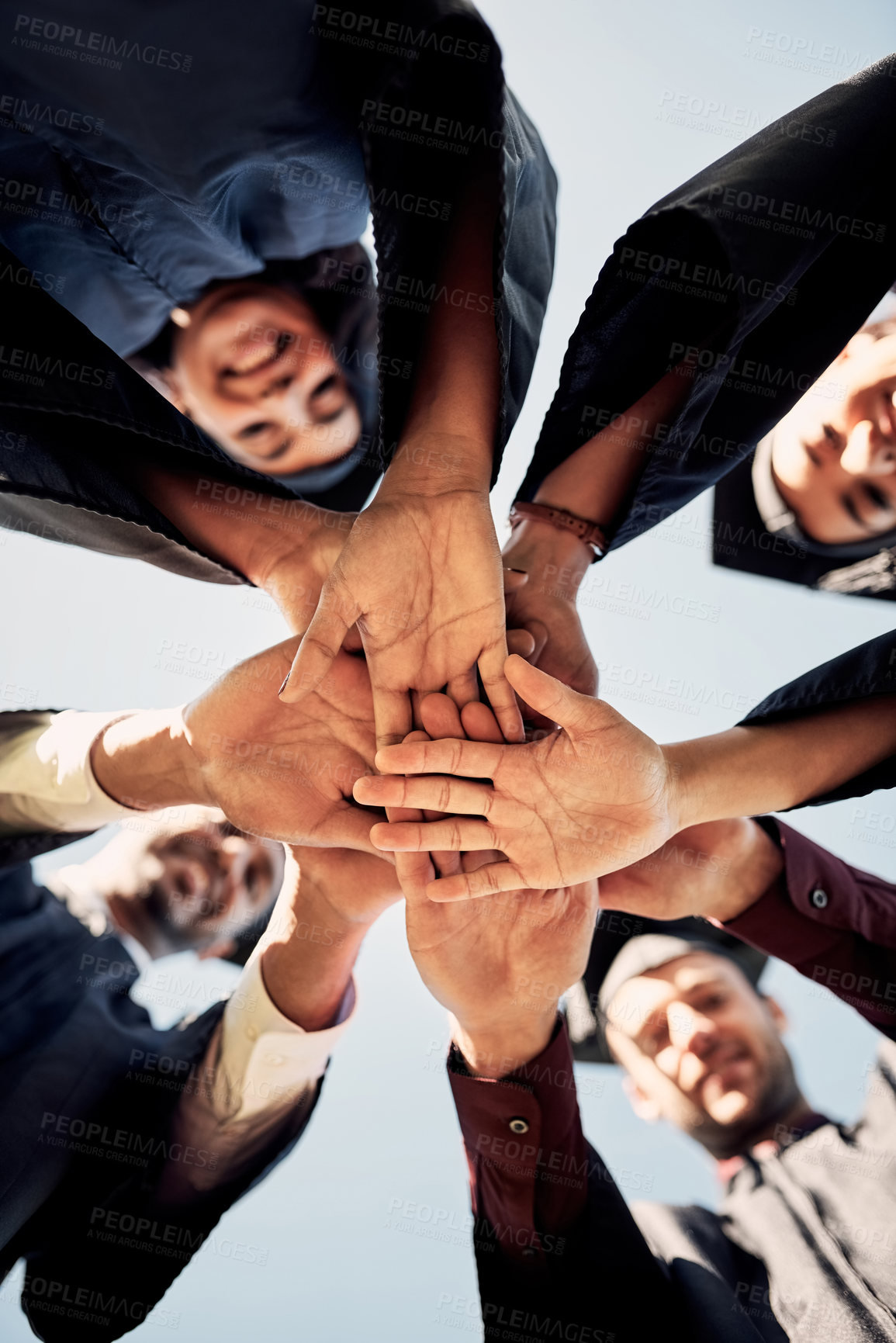 Buy stock photo Closeup shot of a group of students joining their hands together on graduation day