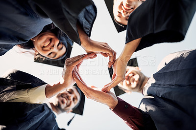 Buy stock photo Closeup shot of a group of students joining their hands together in a circle on graduation day