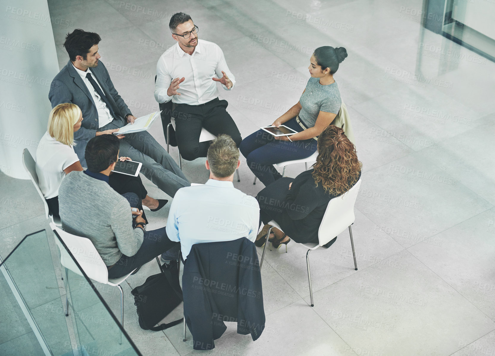 Buy stock photo Shot of a group of coworkers talking together while sitting in a circle in an office