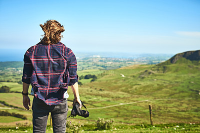 Buy stock photo Countryside, photography and back of man in nature with camera, view and adventure in meadow. Thinking, professional photographer and outdoor with tech for idea, environment and calm in Norway