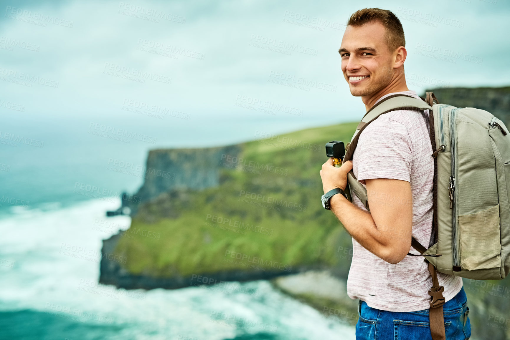 Buy stock photo Man, smile or portrait on cliff for travel, journey and hiking adventure in Ireland. Tourist, happy or ocean view with space for summer vacation, holiday or freedom in nature for scenery or fresh air