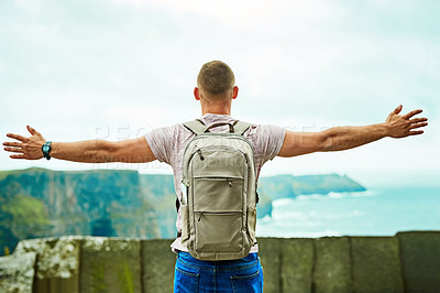 Buy stock photo Rearview shot of an unrecognizable man looking at the view arms outstretched outdoors