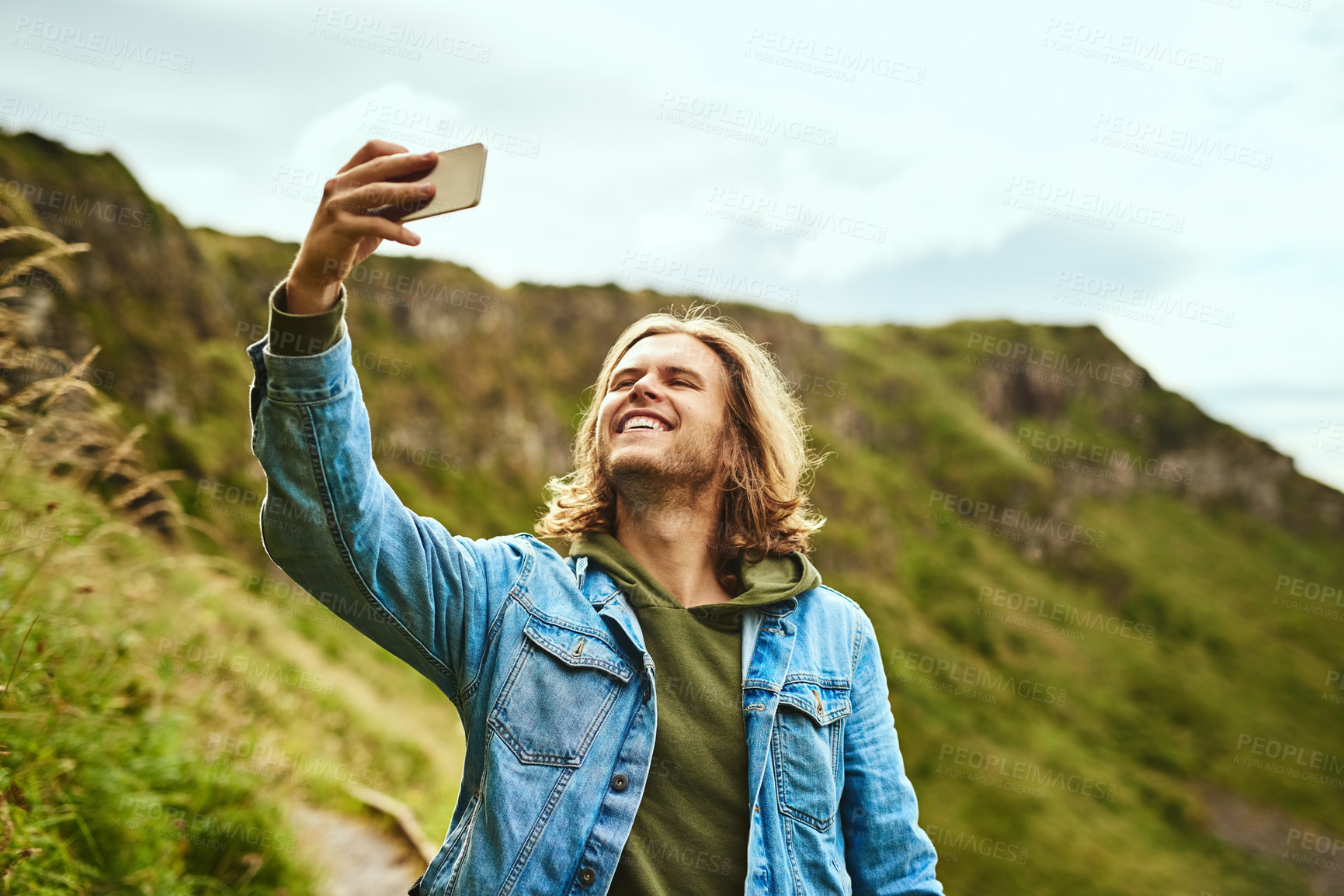 Buy stock photo Shot of a handsome man taking a selfie outdoors