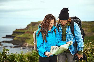 Buy stock photo Shot of a young couple looking at a map for directions outdoors