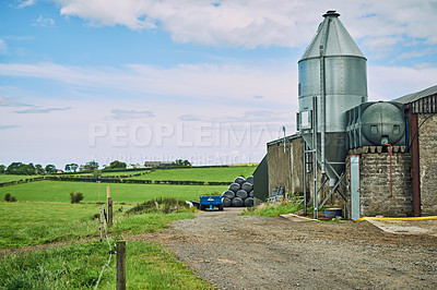 Buy stock photo Outdoor, building and agriculture on farm for production, landscape and dairy factory by blue sky. Sustainable farming, crops and grass growth in countryside for small business, field and pasture