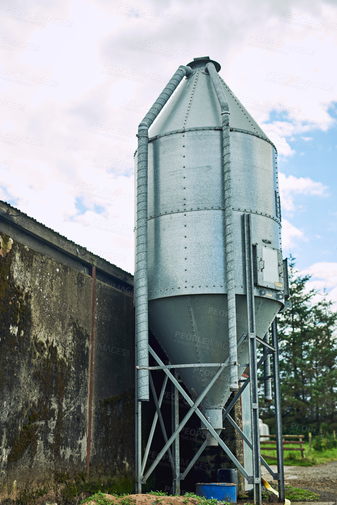 Buy stock photo Agriculture, bulk feed tank for feeding and sustainability on farm for development or growth. Agro, container and equipment for storage of corn in countryside with silo on concrete wall outdoor