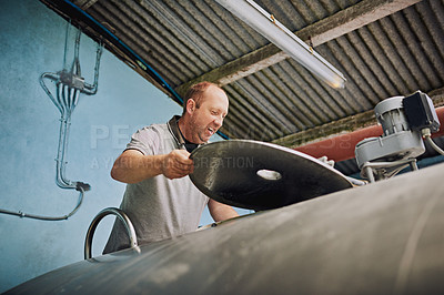 Buy stock photo Farming, warehouse and man with machine for milk production, livestock produce and dairy industry. Agriculture, factory and person with pump, pipe and tank for milking, sustainable business or cattle