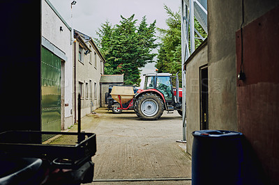 Buy stock photo Farm, agriculture and industrial tractor at warehouse for dairy production, storage and service delivery. Sustainable, transport and agro vehicle in driveway at barn for small business in countryside