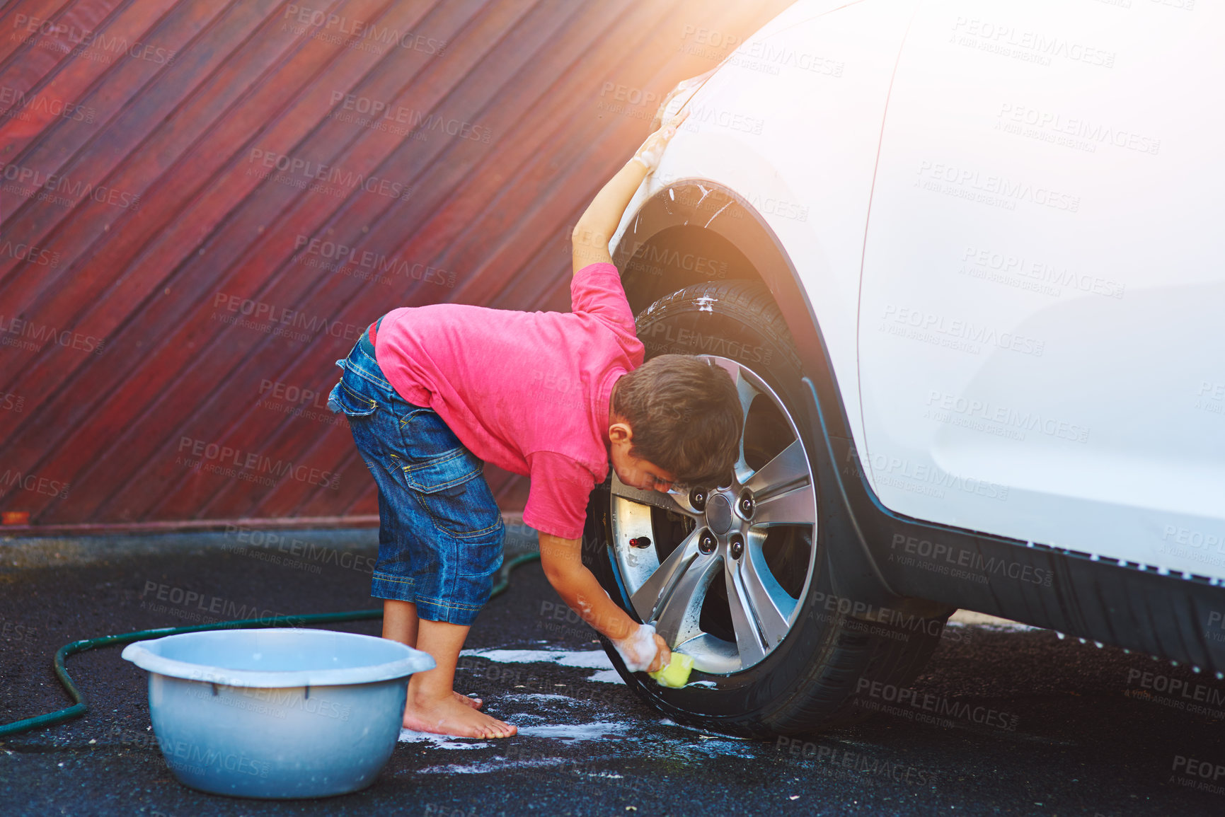 Buy stock photo Full length shot of an adorable little boy washing a car outside