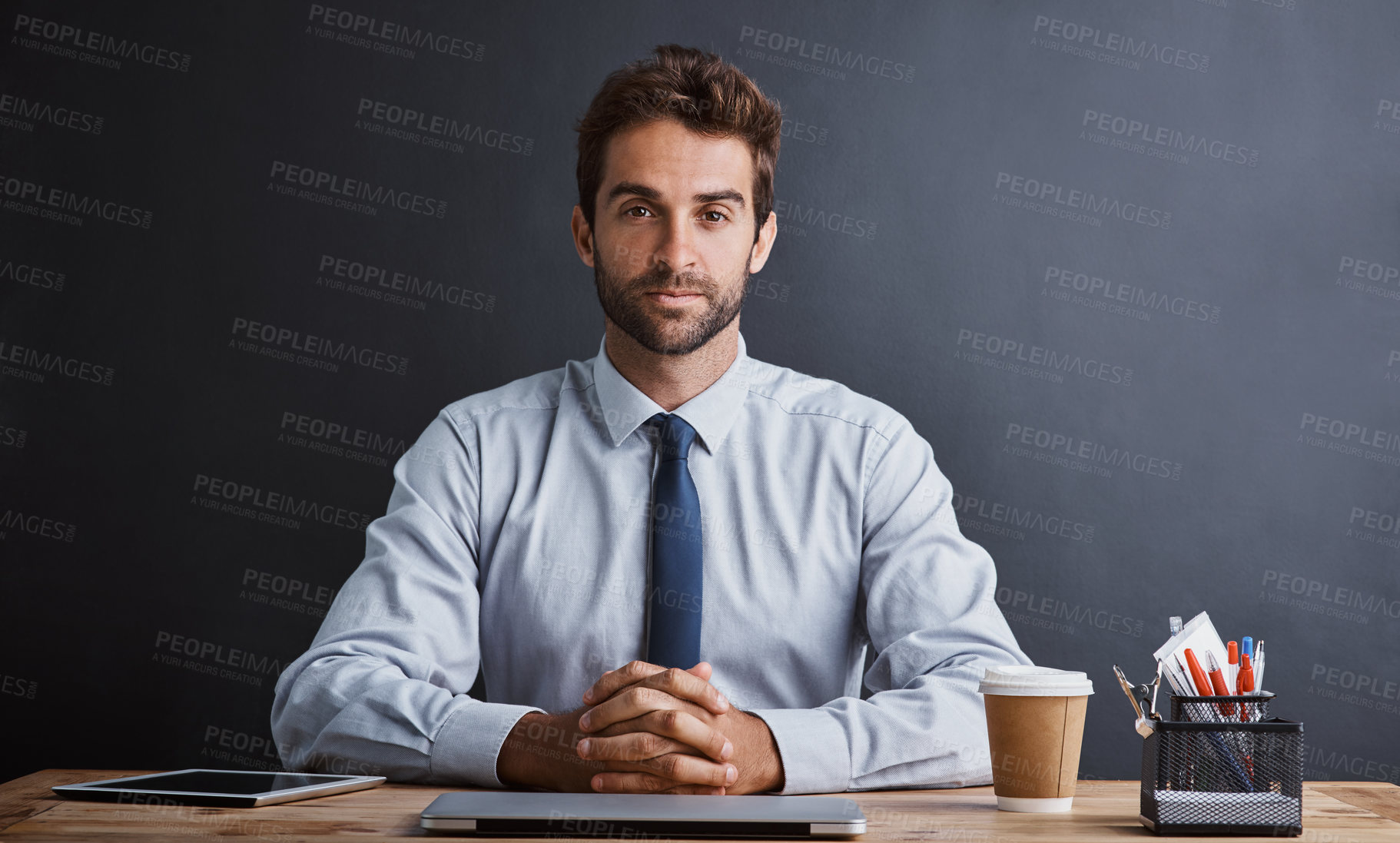 Buy stock photo Businessman, portrait and desk with wall background with confidence as insurance broker, investment or finance. Male person, face and laptop with stationery at table or loan, connectivity or mockup