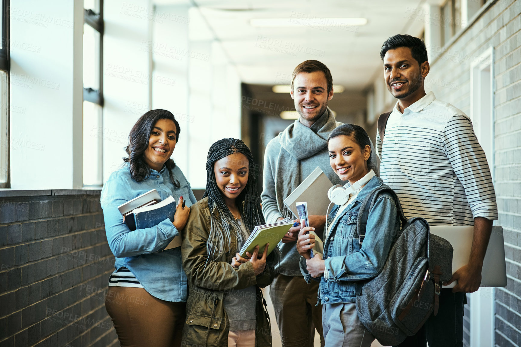 Buy stock photo Cropped portrait of a group of university students standing in a campus corridor