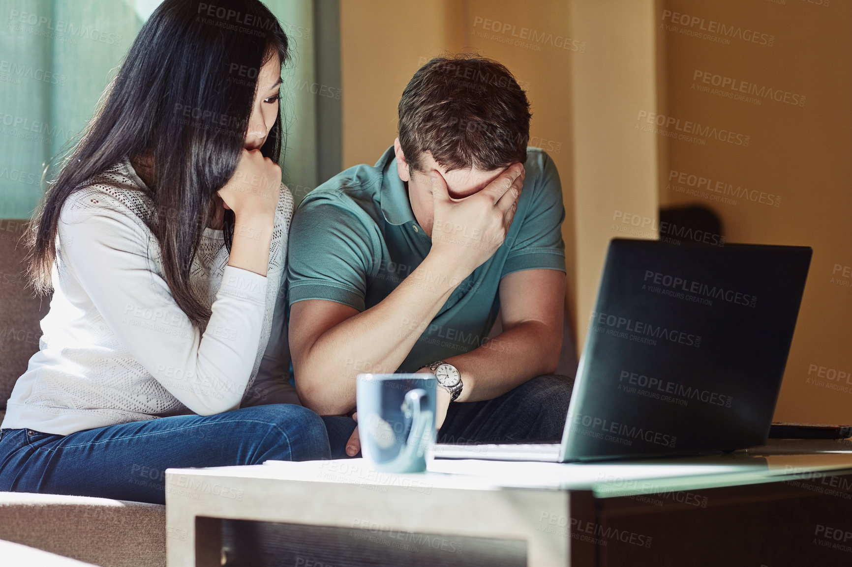 Buy stock photo Shot of a stressed couple sitting in front on their laptop  at home