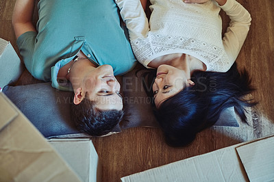 Buy stock photo High angle shot of a happy young couple lying on the floor