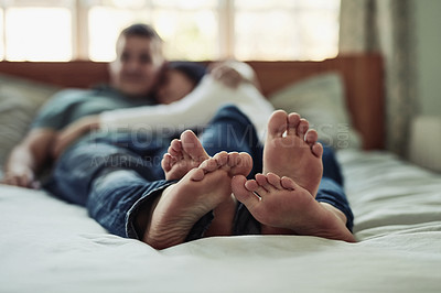 Buy stock photo Shot of a couple's feet as they lay on bed