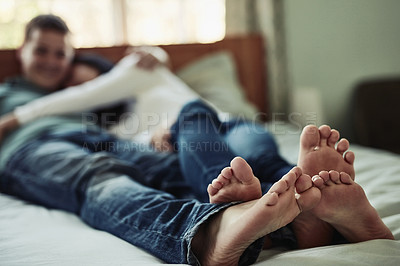 Buy stock photo Shot of a couple's feet as they lay on bed