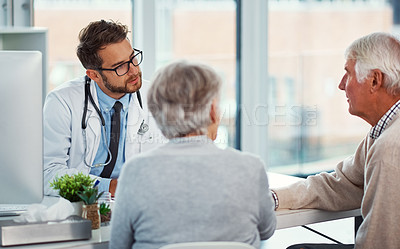 Buy stock photo Shot of a doctor having a consultation with a senior couple in a clinic