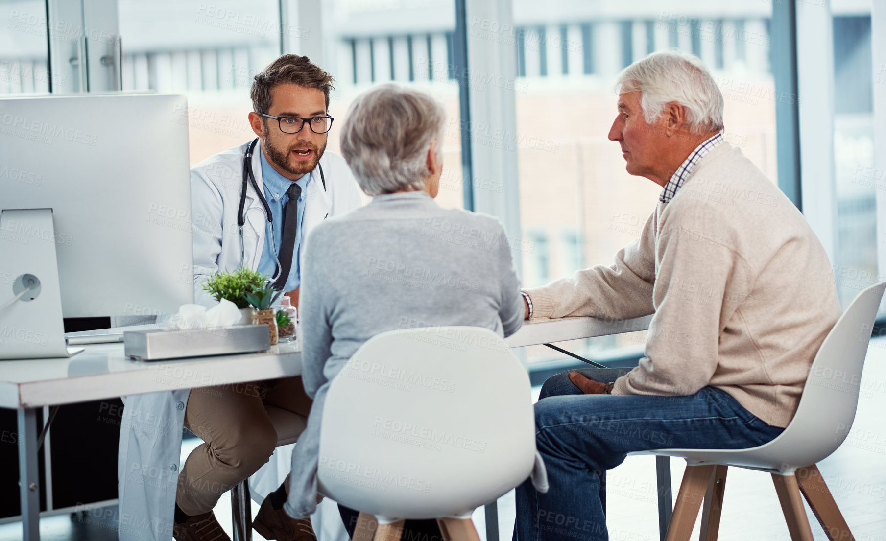 Buy stock photo Shot of a doctor having a consultation with a senior couple in a clinic