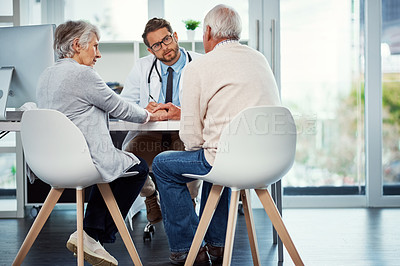 Buy stock photo Shot of a doctor having a consultation with a senior couple in a clinic