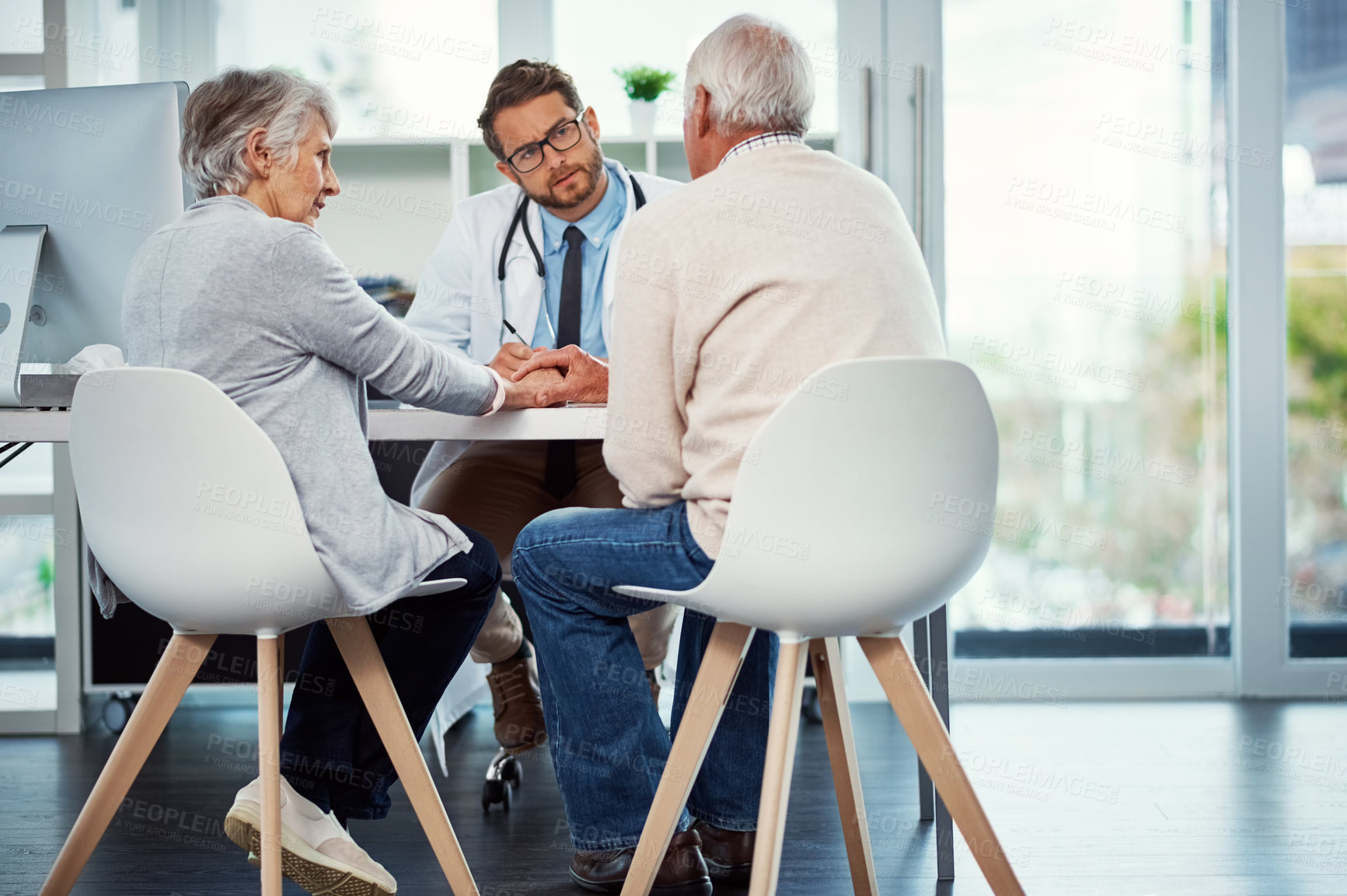 Buy stock photo Shot of a doctor having a consultation with a senior couple in a clinic