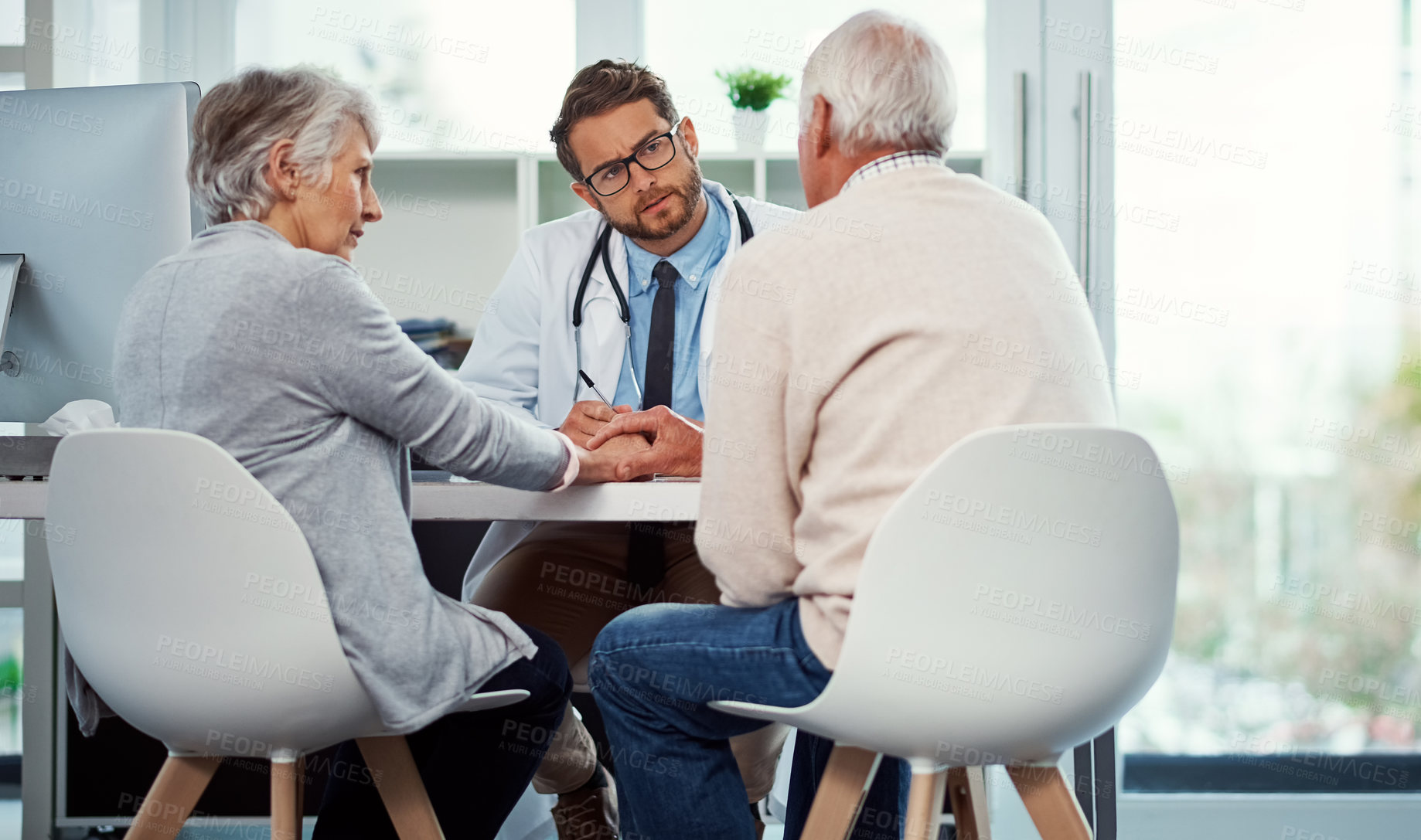 Buy stock photo Shot of a doctor having a consultation with a senior couple in a clinic