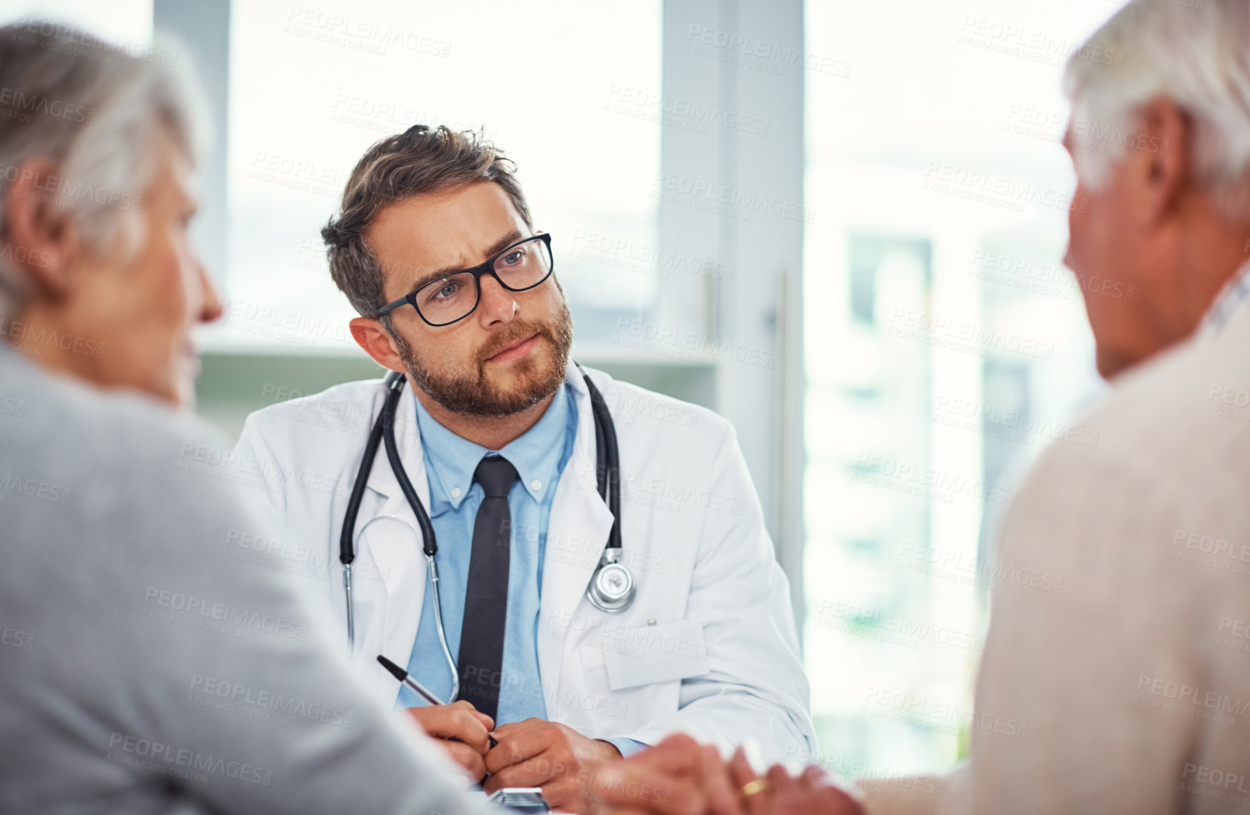 Buy stock photo Shot of a doctor having a consultation with a senior couple in a clinic