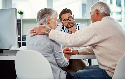 Buy stock photo Shot of a senior man consoling his wife during a consultation with a doctor in a clinic