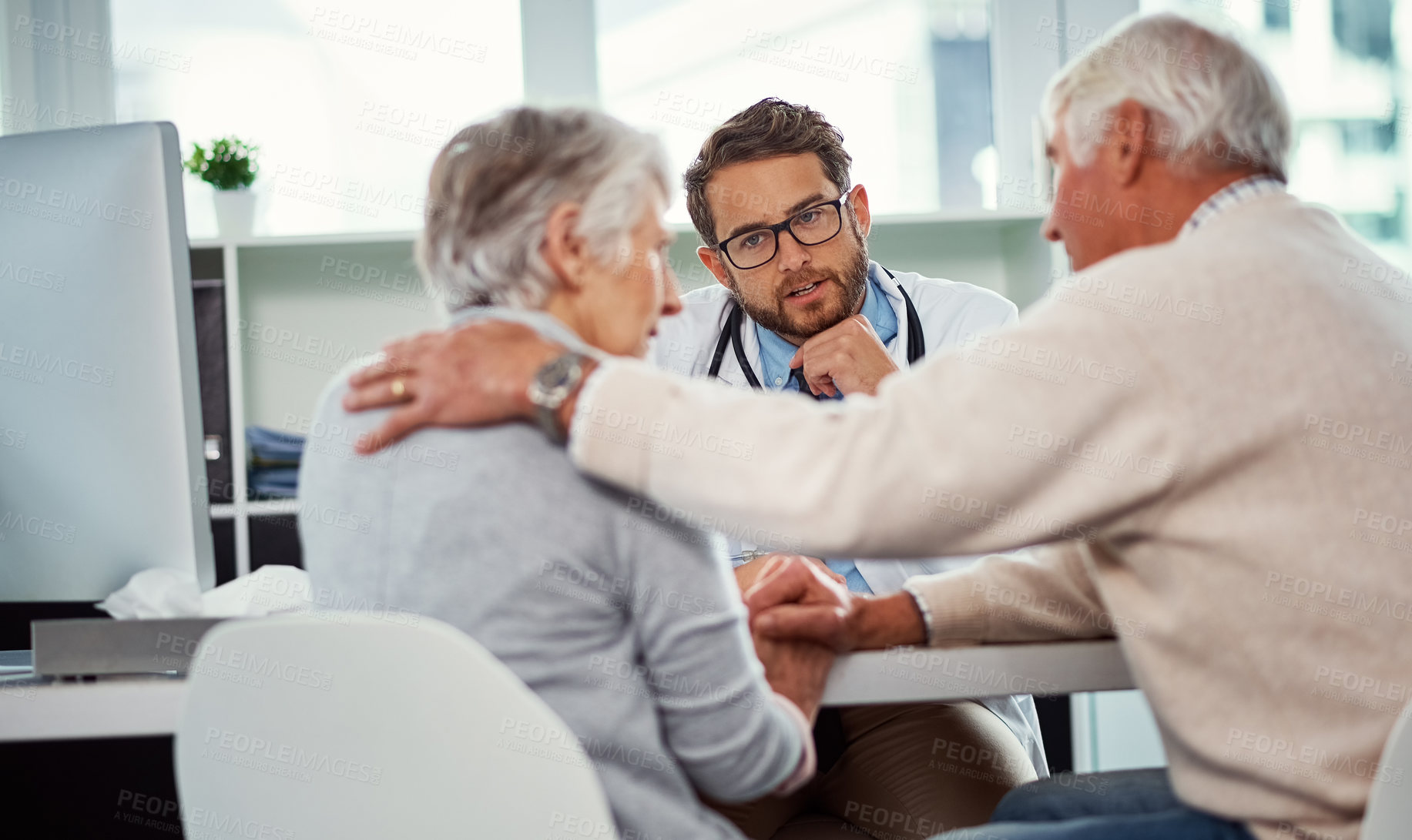 Buy stock photo Shot of a senior man consoling his wife during a consultation with a doctor in a clinic