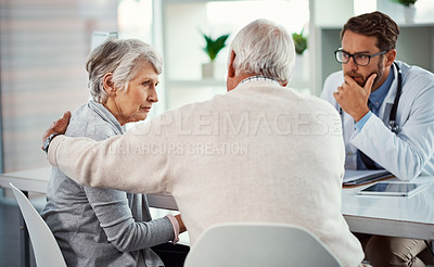 Buy stock photo Shot of a senior man consoling his wife during a consultation with a doctor in a clinic