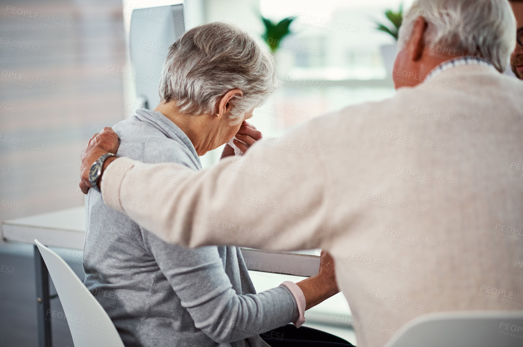 Buy stock photo Shot of a senior man consoling his wife in a clinic