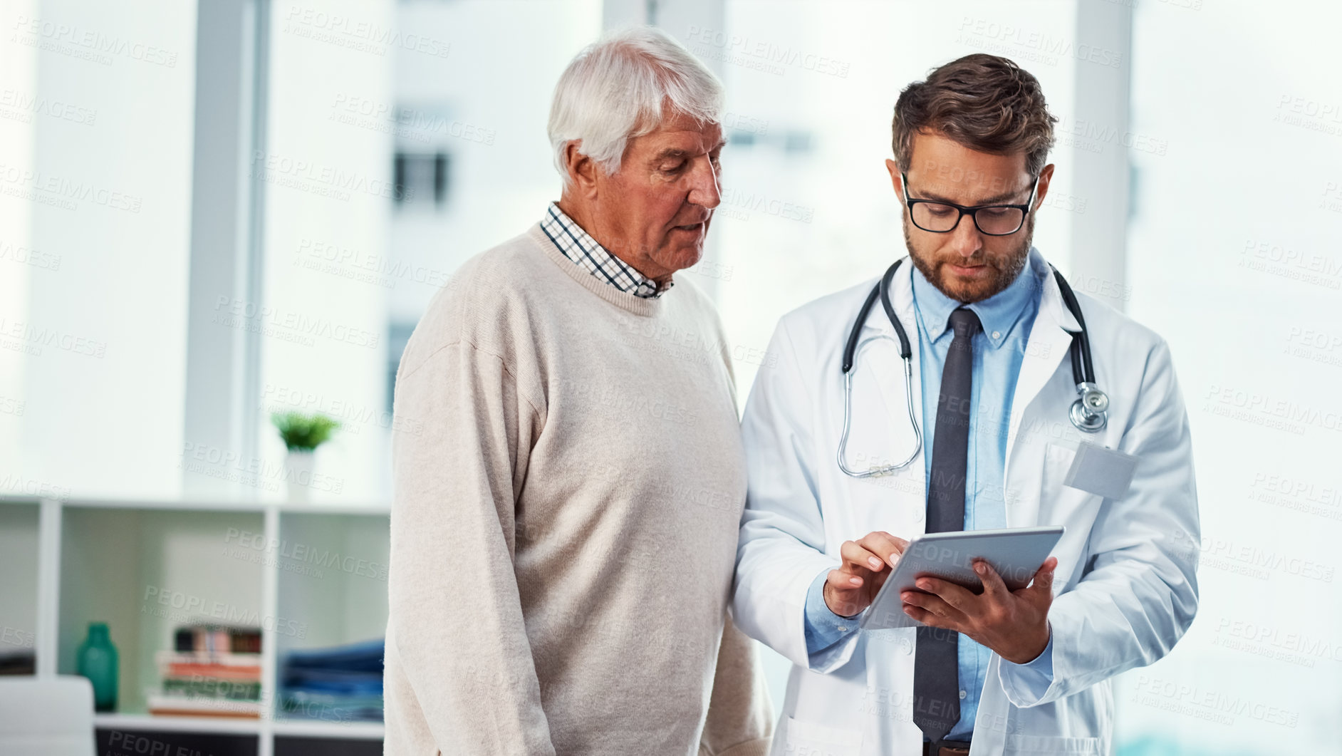 Buy stock photo Shot of a doctor discussing something on a digital tablet with a senior patient in a clinic