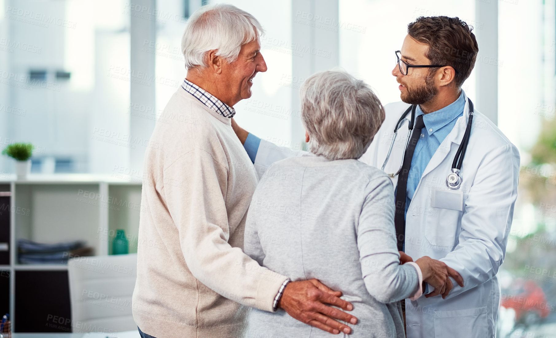 Buy stock photo Shot of a doctor comforting a senior couple in a clinic