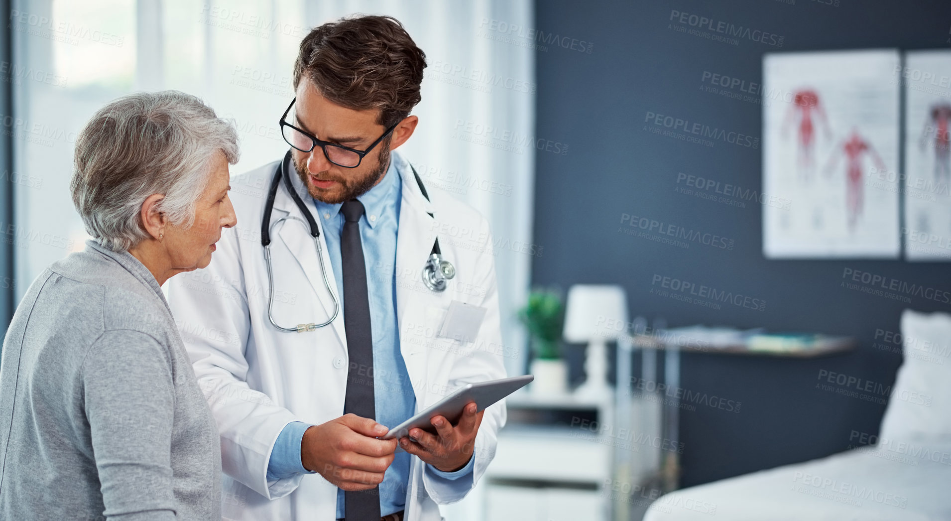 Buy stock photo Shot of a doctor discussing something on a digital tablet with a senior patient in a clinic