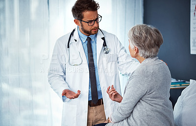 Buy stock photo Shot of a doctor examining a senior patient in a clinic