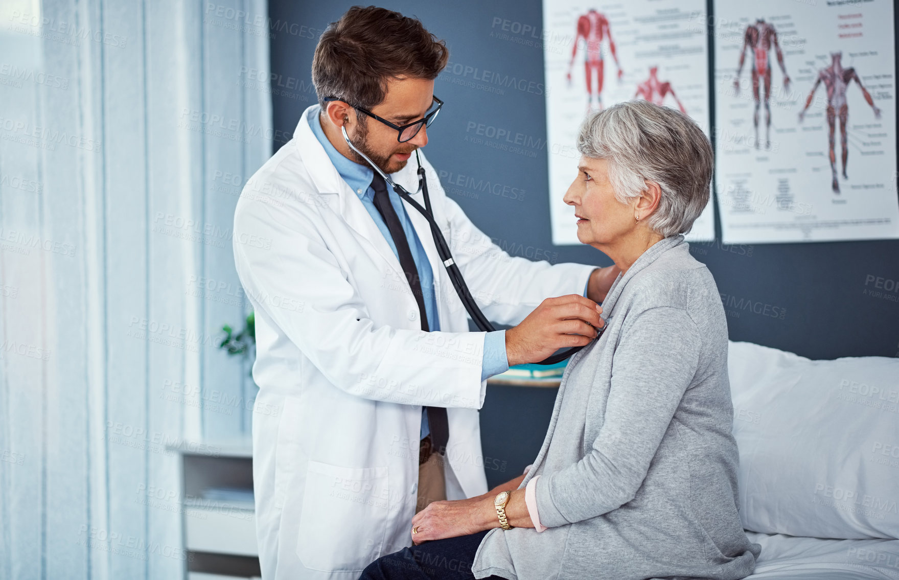 Buy stock photo Shot of a doctor examining a senior patient with a stethoscope in a clinic