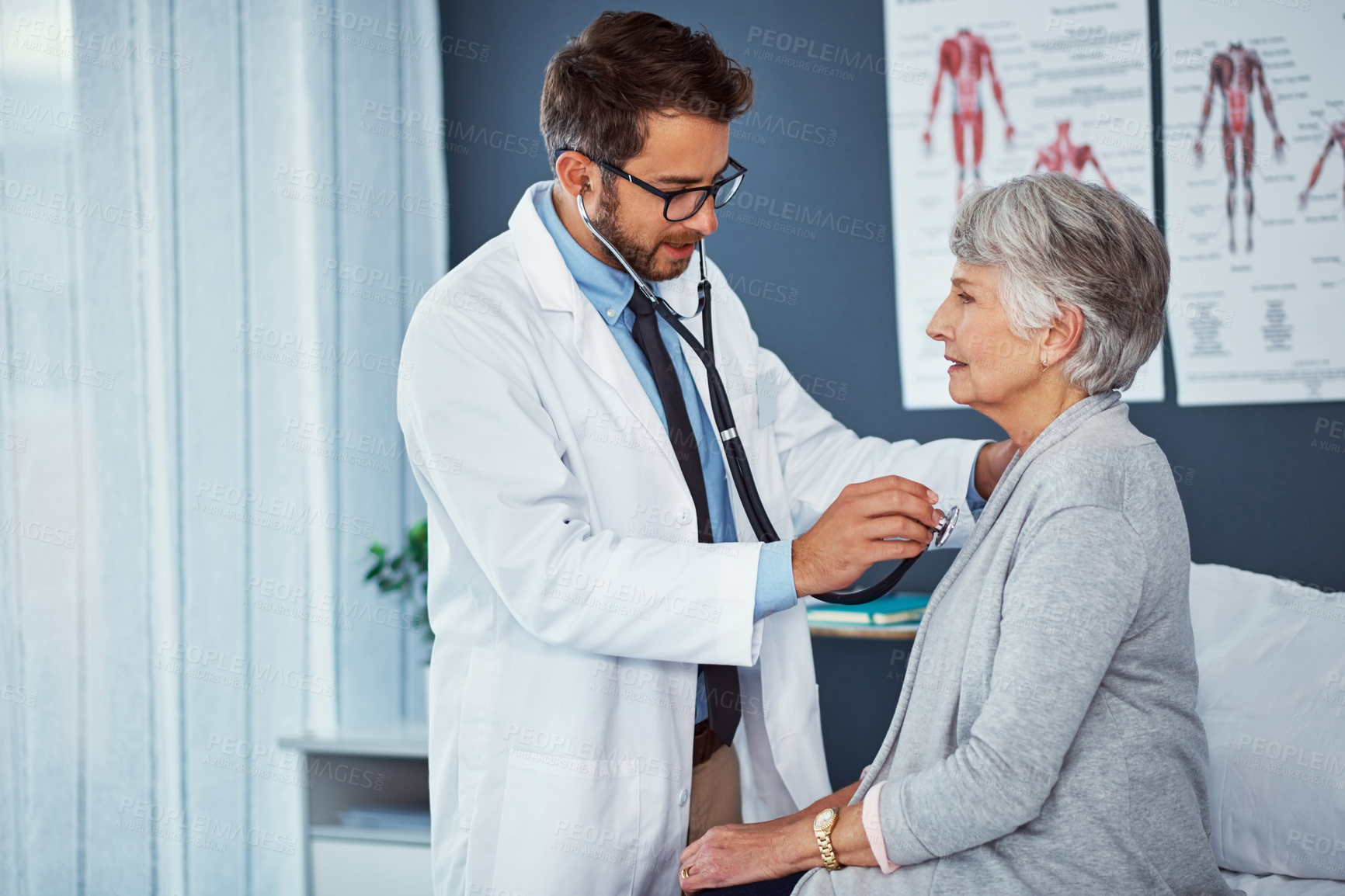 Buy stock photo Shot of a doctor examining a senior patient with a stethoscope in a clinic