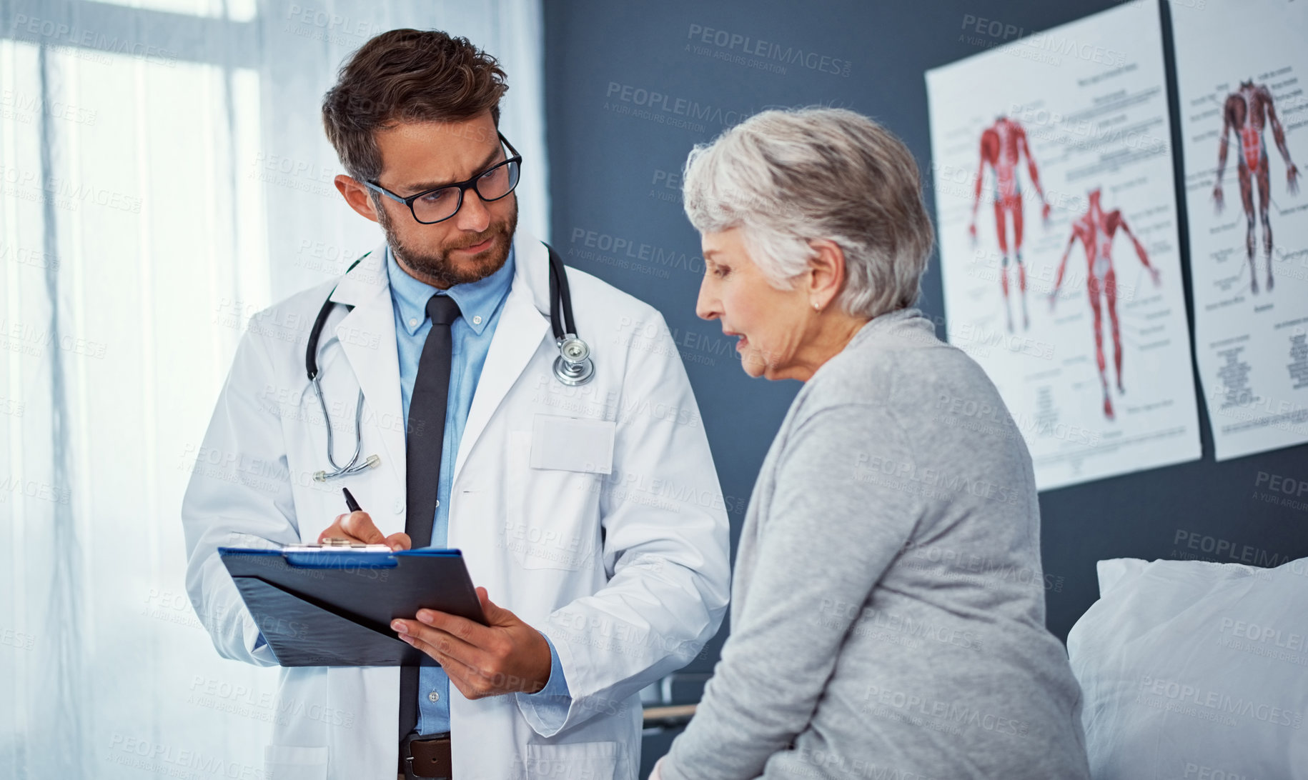 Buy stock photo Shot of a doctor writing notes while examining a senior patient in a clinic