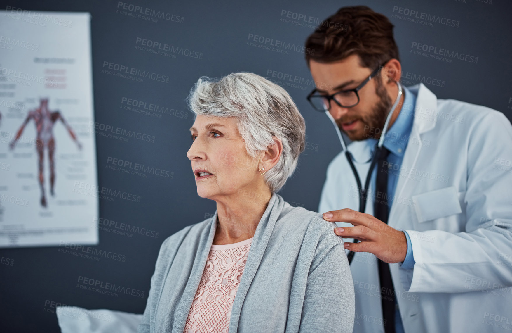 Buy stock photo Shot of a doctor examining a senior patient with a stethoscope in a clinic