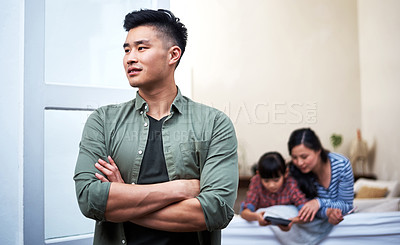 Buy stock photo Shot of a young man relaxing with his family at home