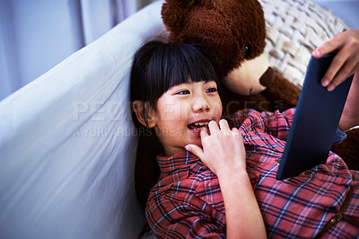 Buy stock photo Shot of a little girl using a digital tablet at home