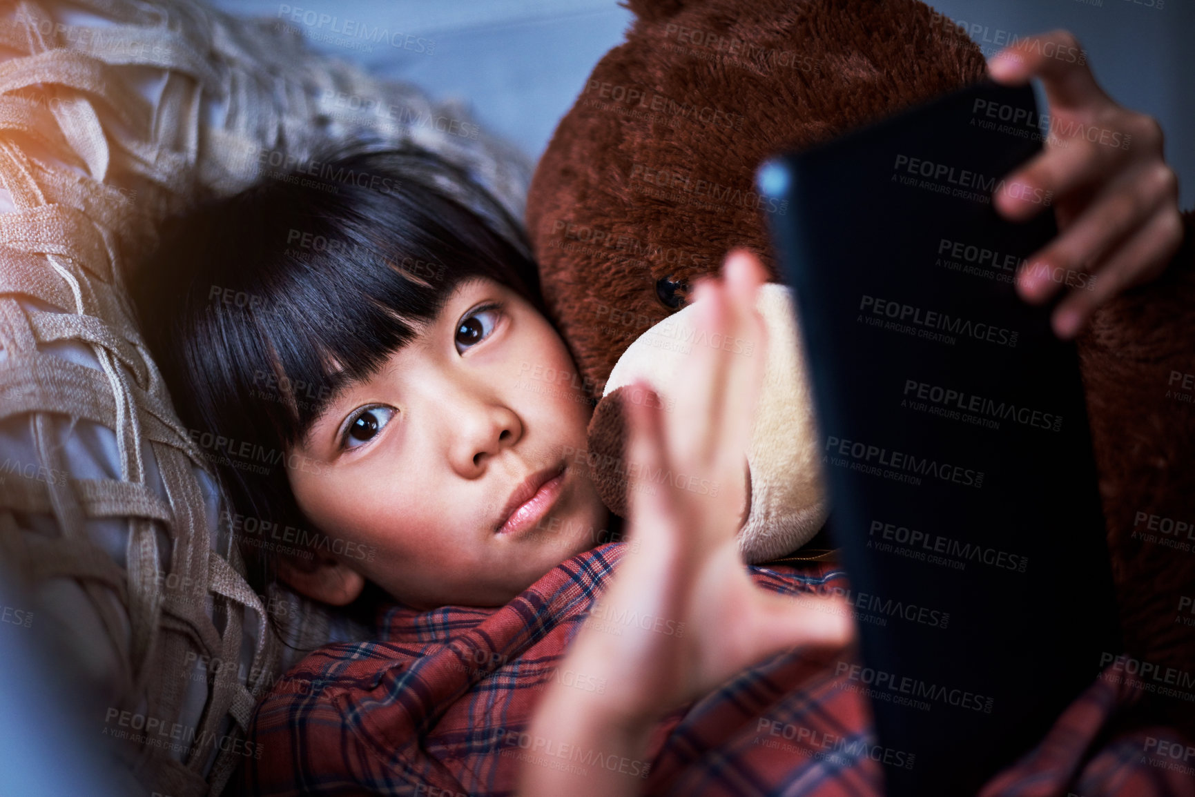 Buy stock photo Tablet, portrait and child on bed in home with watching movie, show or series on app on weekend. Relax, teddy bear and Asian girl kid with digital technology for streaming film in bedroom at house.