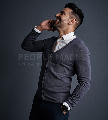 Buy stock photo Studio shot of a stylish young businessman using a mobile phone against a gray background