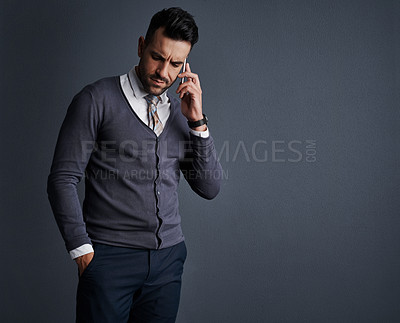 Buy stock photo Studio shot of a stylish young businessman using a mobile phone against a gray background