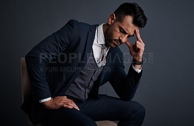 Buy stock photo Studio shot of a young businessman looking stressed out against a gray background