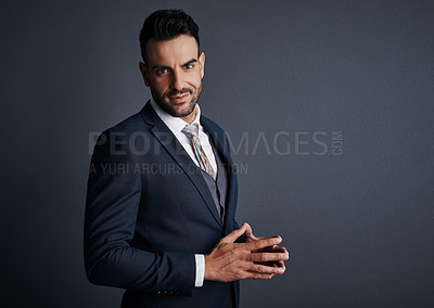 Buy stock photo Studio shot of a stylish and confident young businessman posing against a gray background